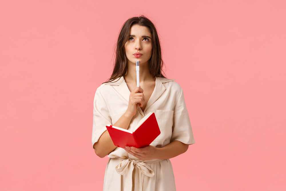 thoughtful-creative-young-woman-making-list-pouting-looking-up-pensive-inspired-holding-red-notebook-pen-create-new-poem-prepare-exam-thinking-pink-wall thoughtful-creative-young-woman-making-list-pouting-looking-up-pensive-inspired-holding-red-notebook-pen-create-new-poem-prepare-exam-thinking-pink-wall